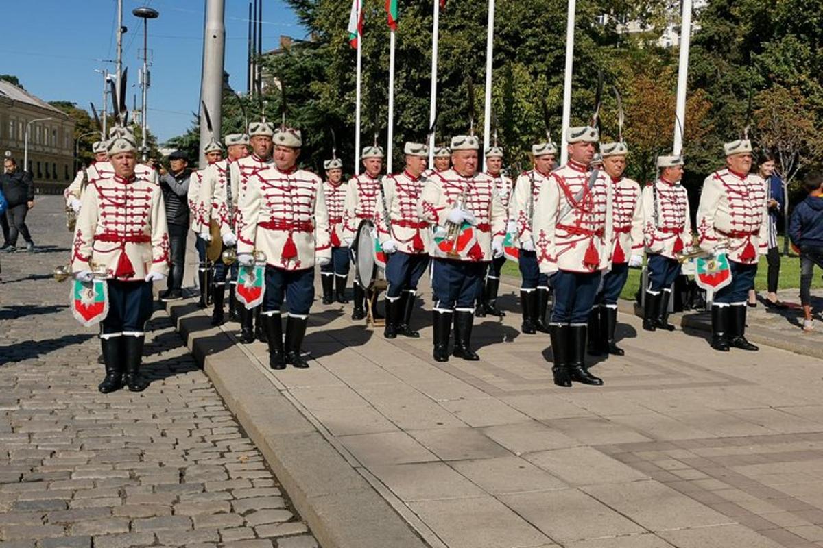 a marching band in red and white uniforms walking down a street