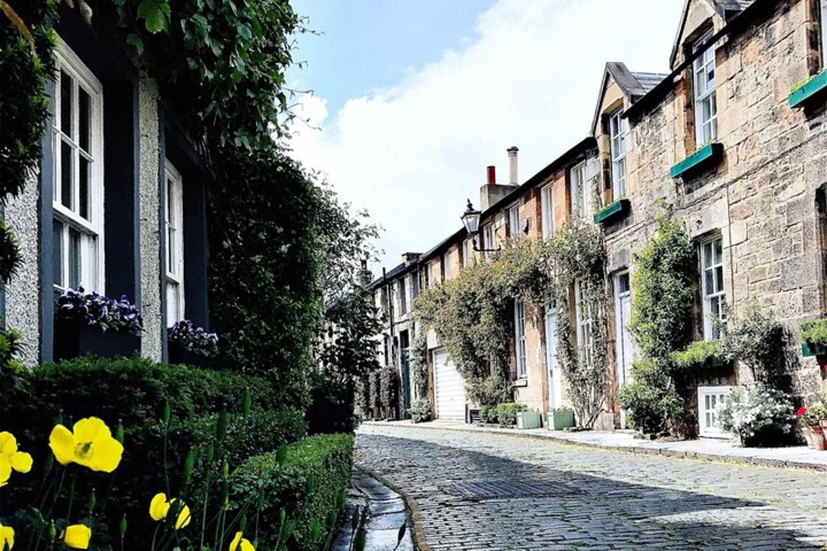 Una calle adoquinada con edificios y flores amarillas.