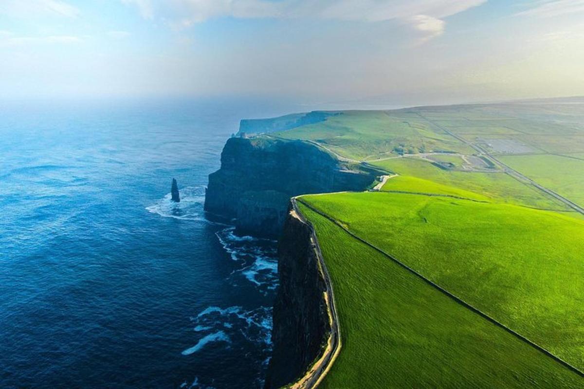 an aerial view of the ocean with a cliff