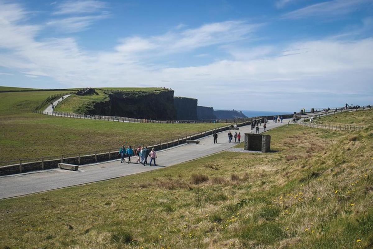 a group of people walking on a road near a cliff