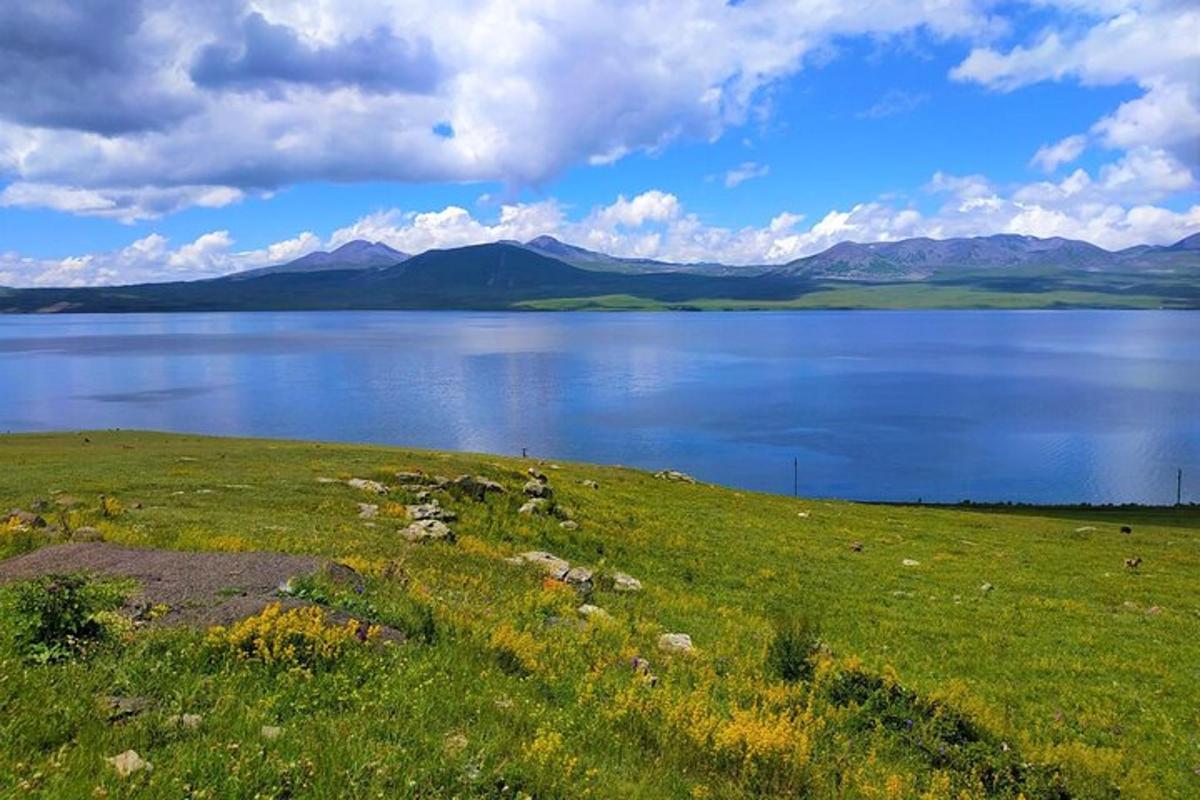 stórt vatn með fjöllum í bakgrunni