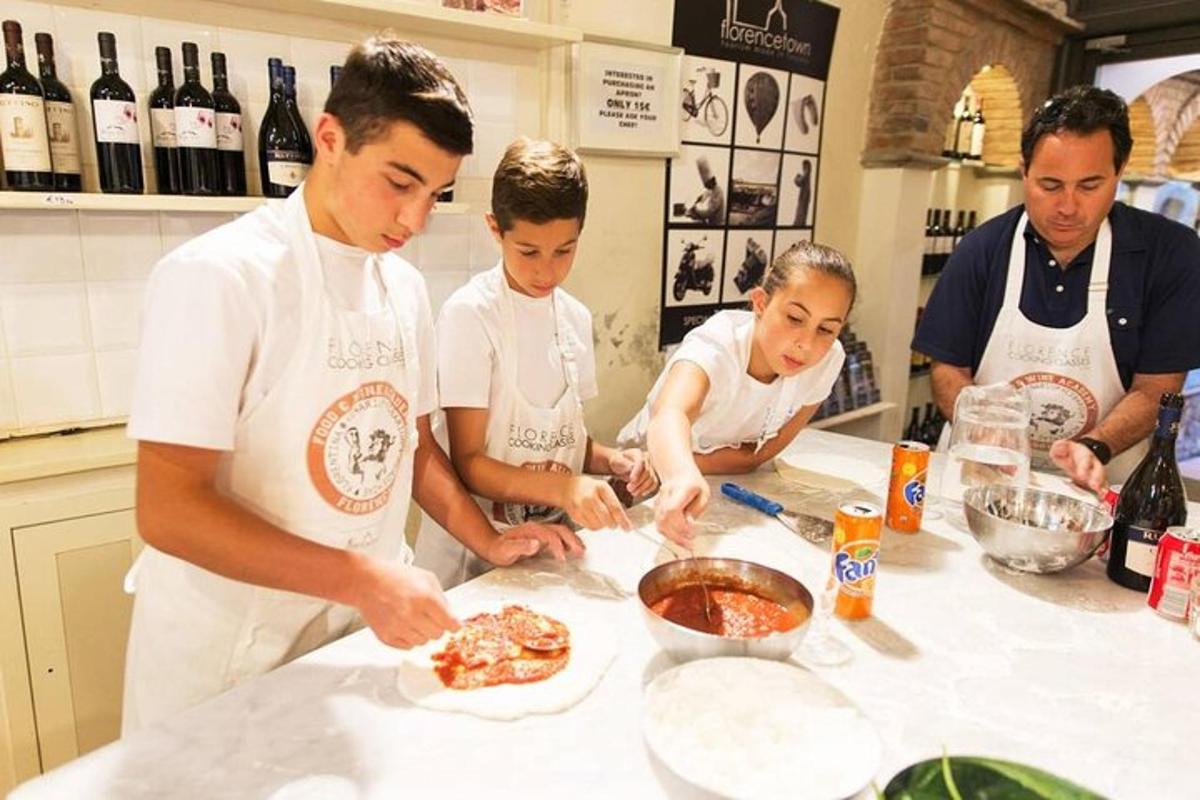 skupina lidí v kuchyni připravuje pizzu