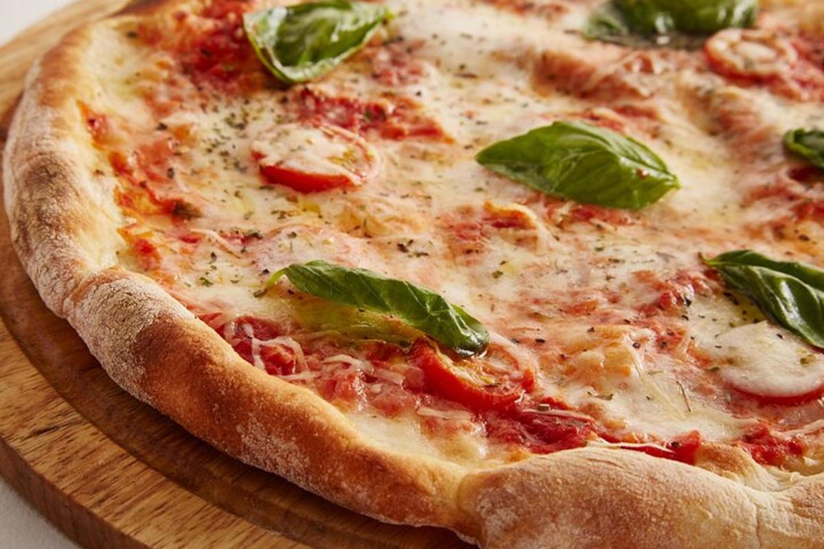 pizza ležící na dřevěném prkénku