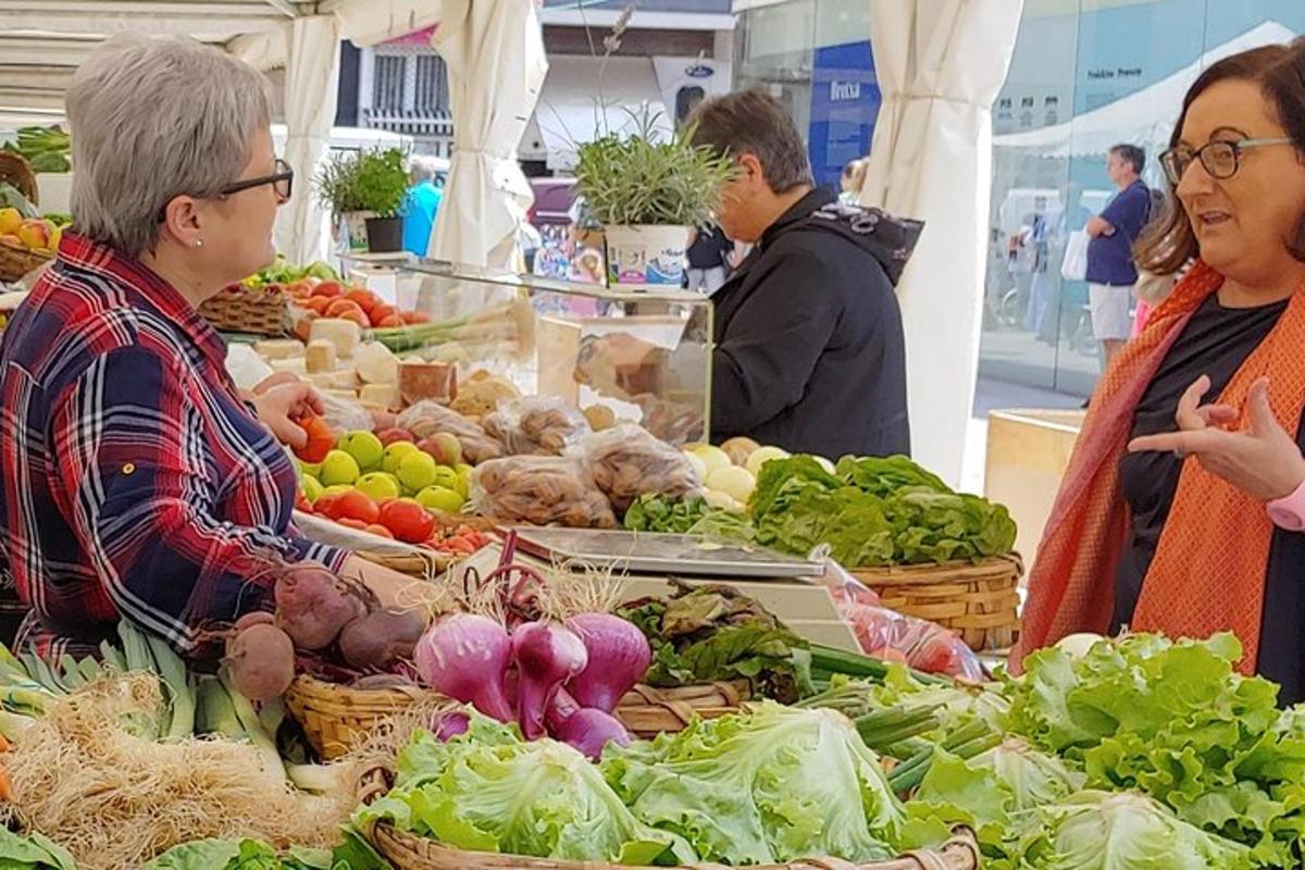 一群人站在市场周围，手里拿着蔬菜