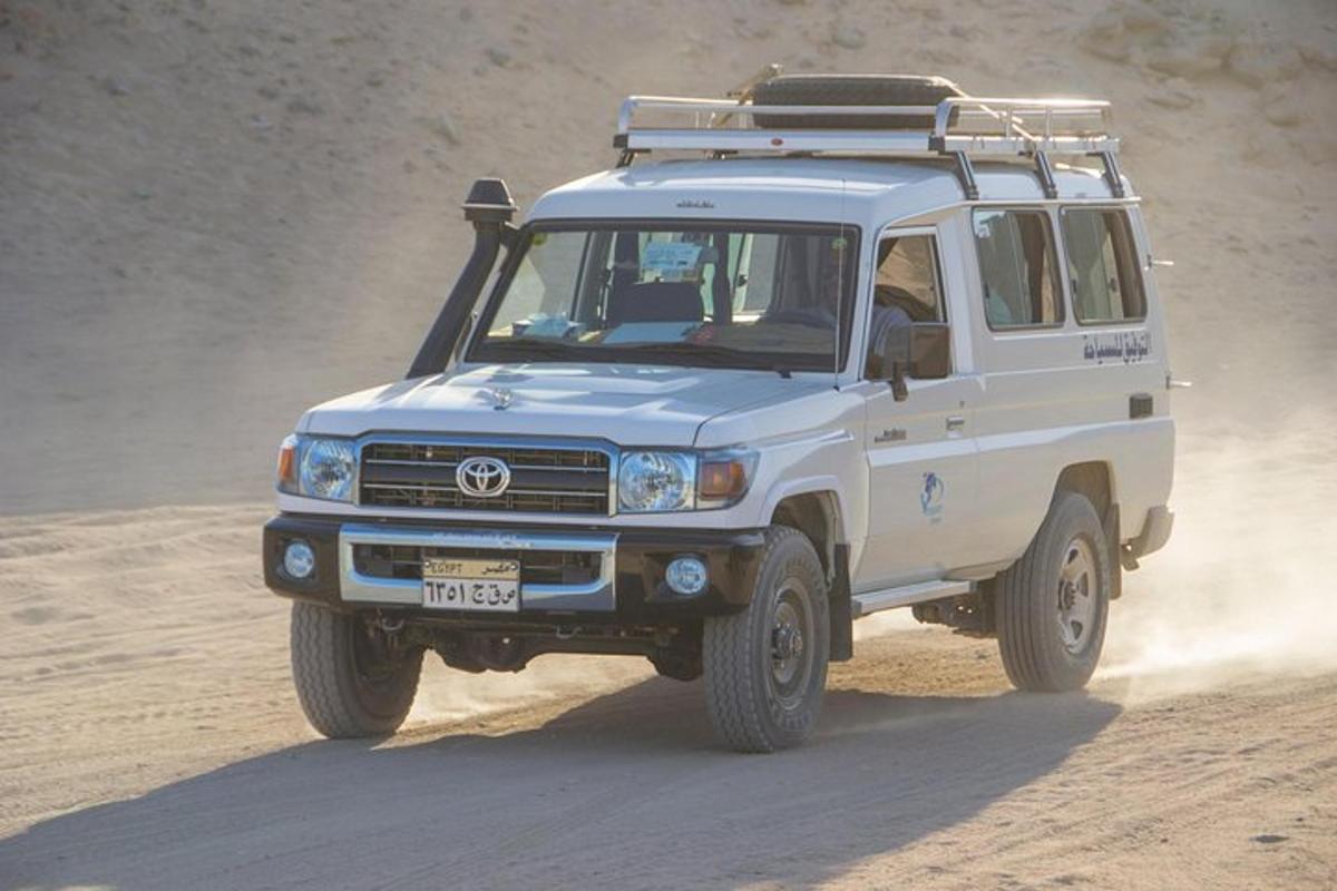 a white truck driving on a dirt road