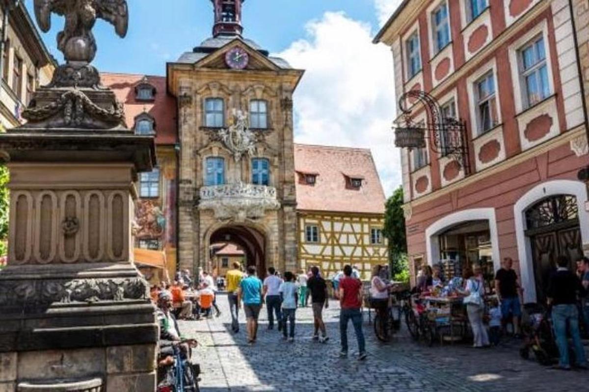 a group of people walking down a street with a clock tower