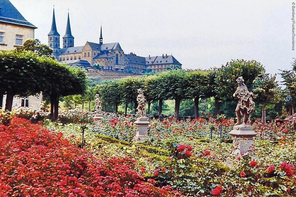 a garden with flowers and a castle in the background