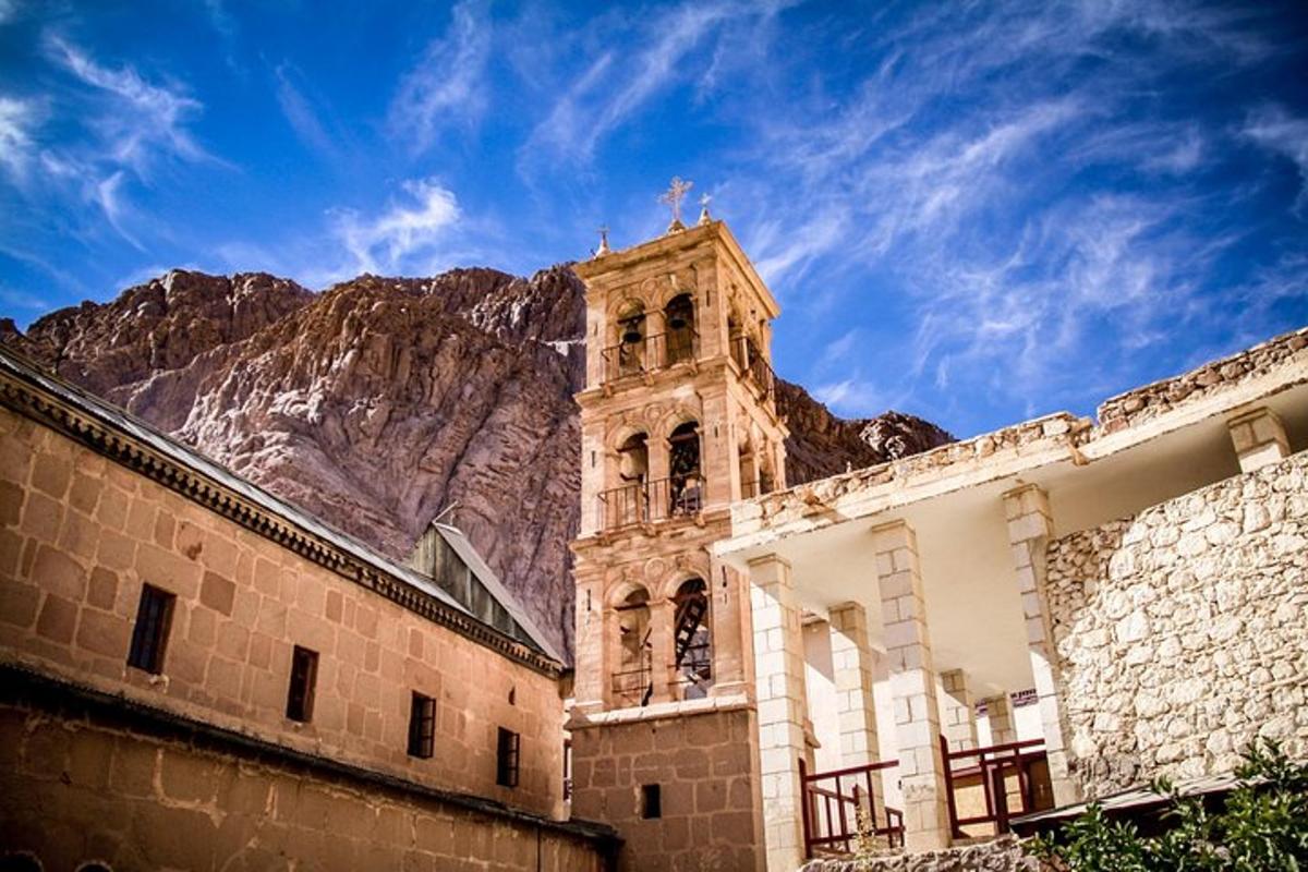 un edificio con una torre dell'orologio di fronte a una montagna