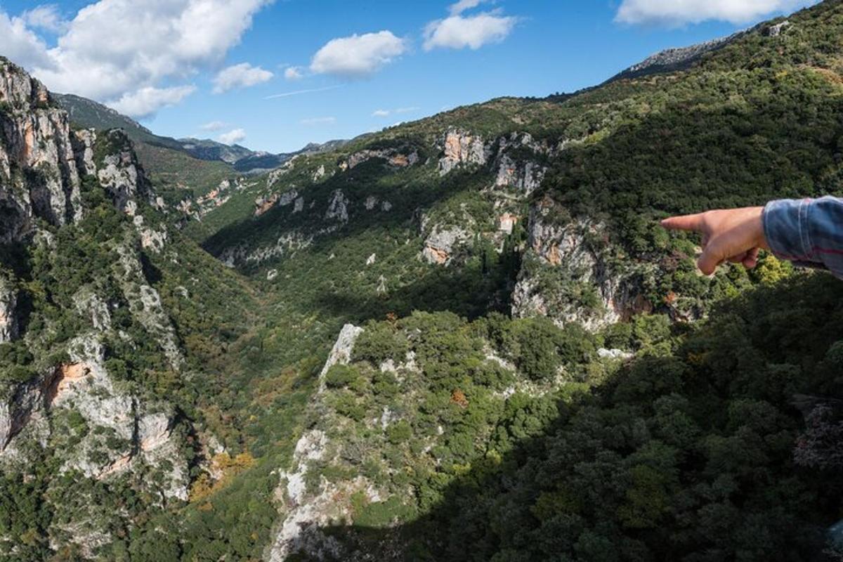 ένα άτομο δείχνει προς μια ορεινή κοιλάδα