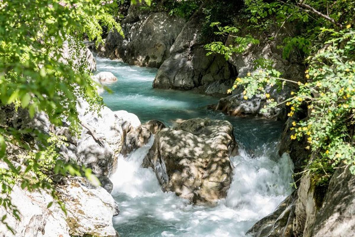 ένα ποτάμι με γαλάζια νερά, βράχια και δέντρα