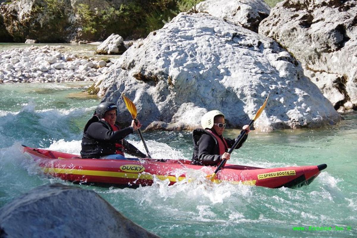 two people in a red kayak in the water