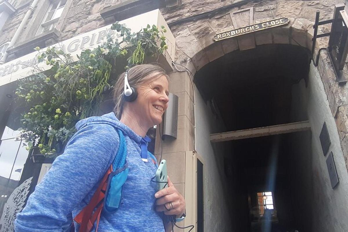 una dona amb auriculars dempeus fora d'un edifici