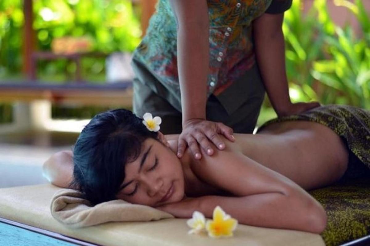 a woman laying on a surfboard getting a massage