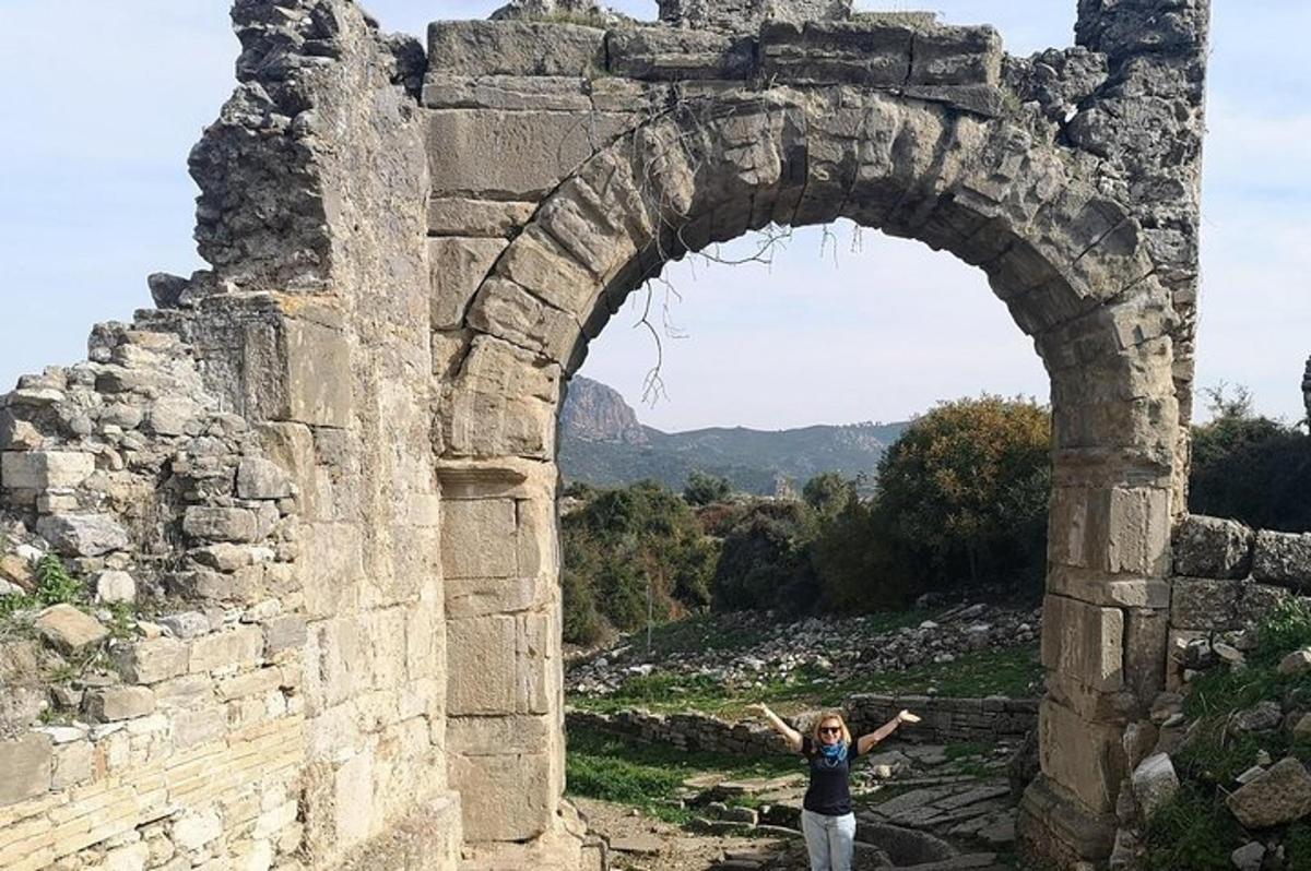 una donna in piedi sotto un arco in un edificio in pietra