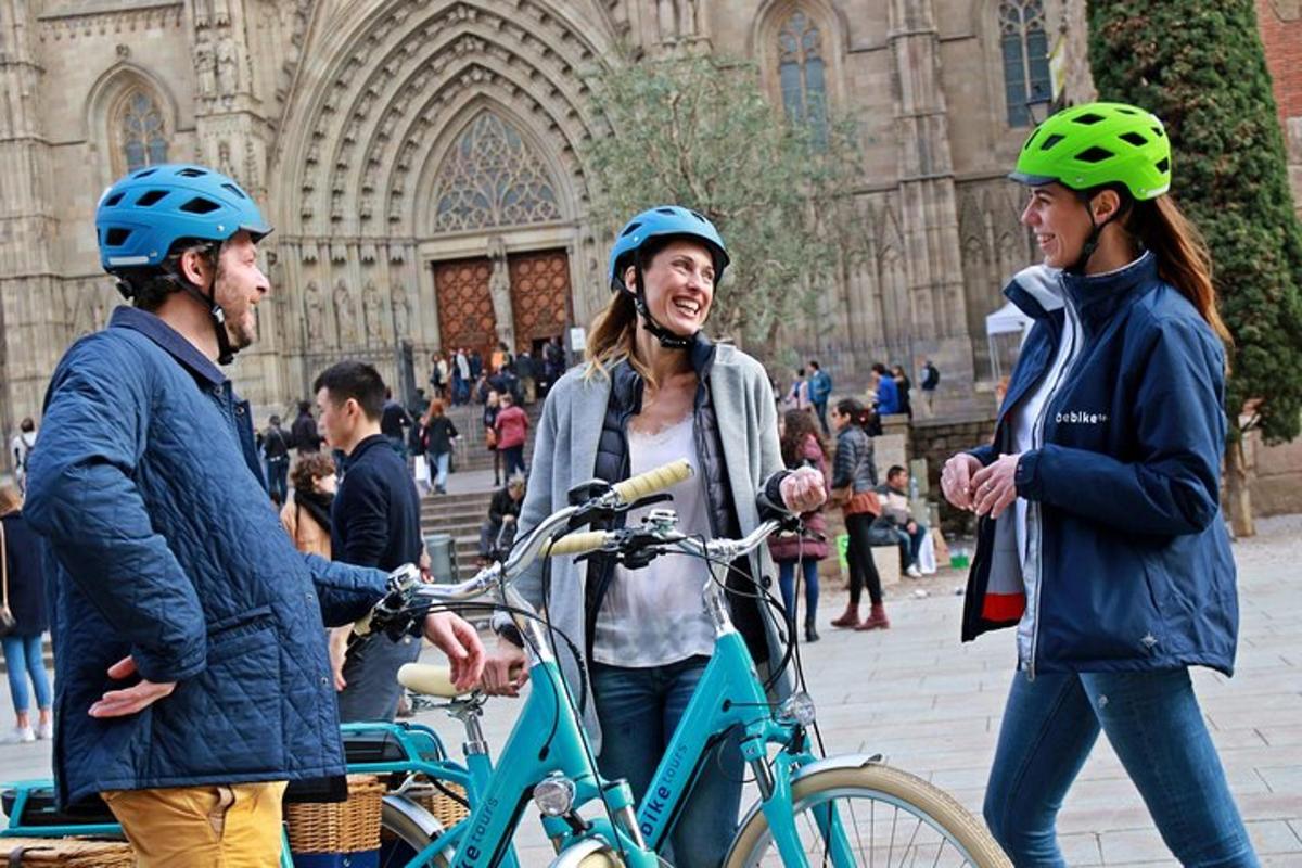 um grupo de três pessoas com capacetes e uma bicicleta