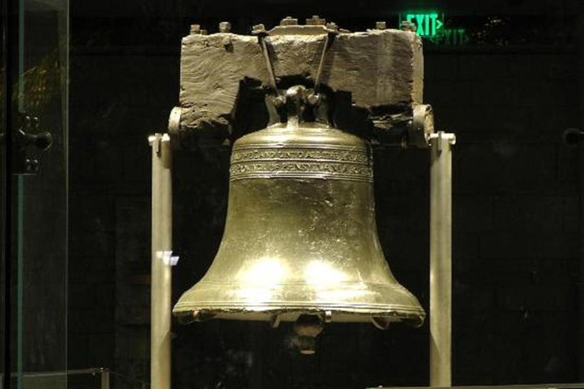 a liberty bell with a street sign in the background