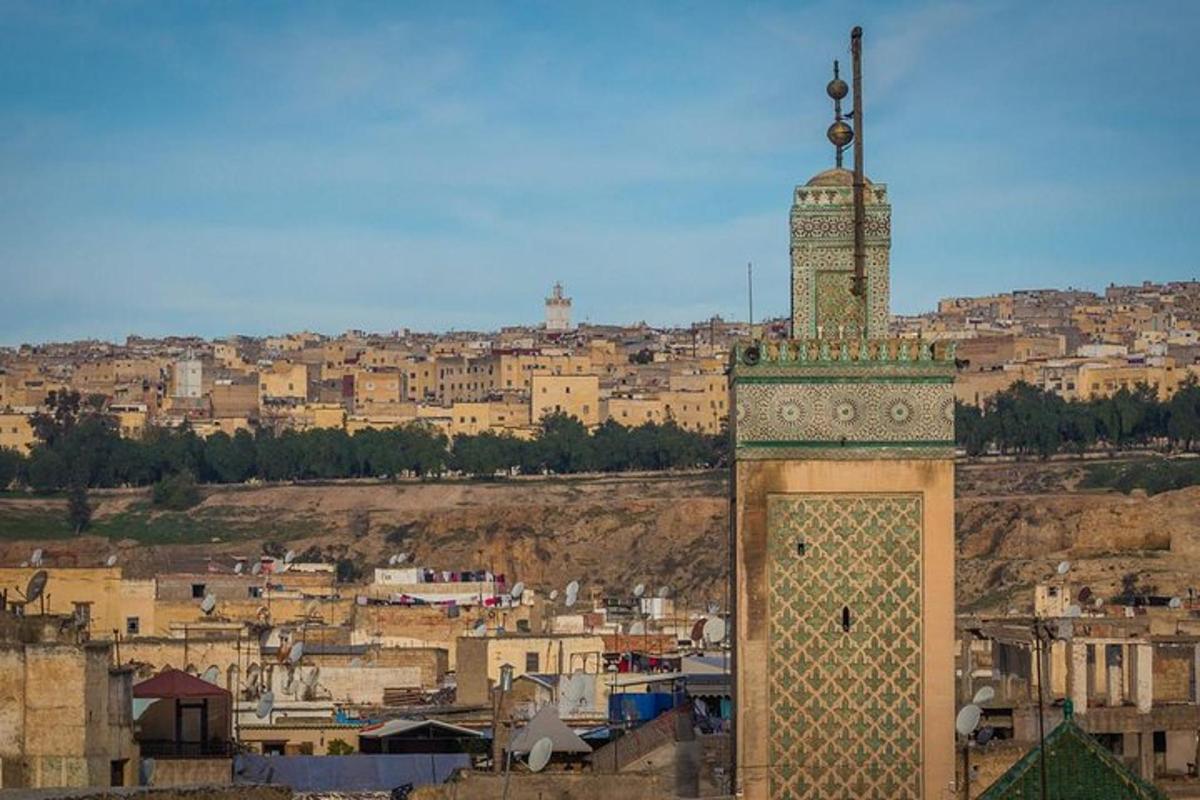 une grande tour d'horloge avec une ville en arrière-plan