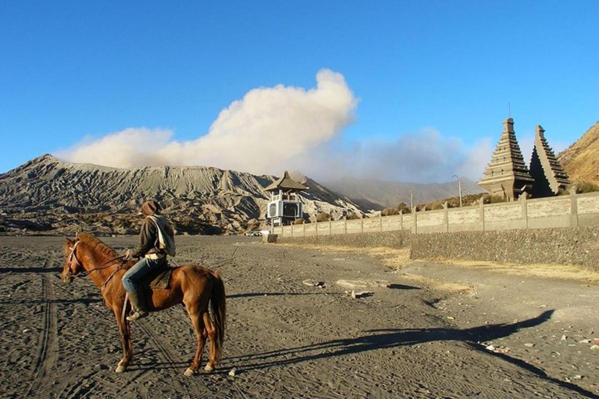 a man riding a horse on a dirt road