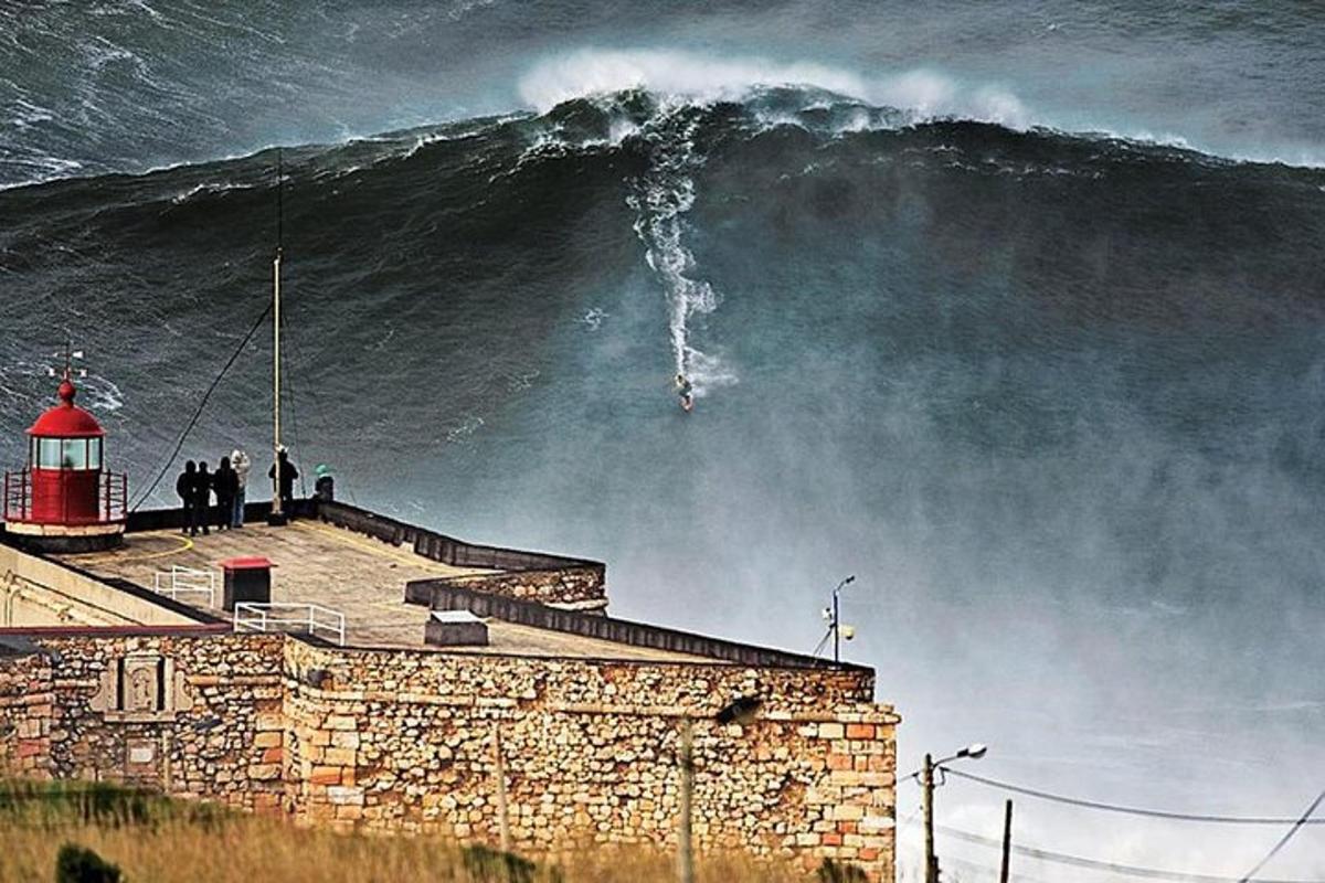a large wave is crashing on a lighthouse