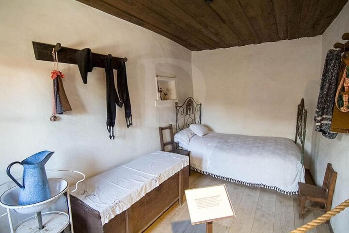 Una habitación con dos camas y un jarrón azul en la pared.