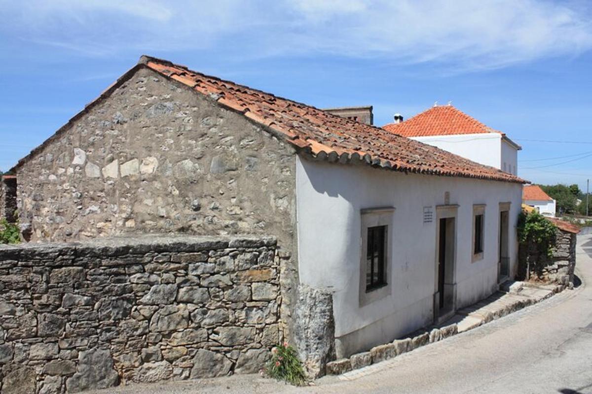 Un edificio antiguo con un muro de piedra al lado de una calle.