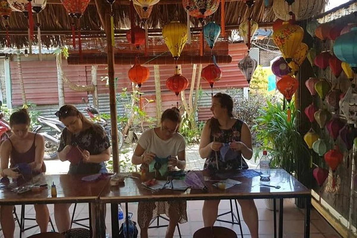 sekumpulan orang duduk di meja dengan tanglung kertas
