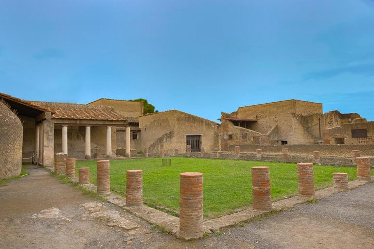 un antico edificio con colonne ed erba di fronte