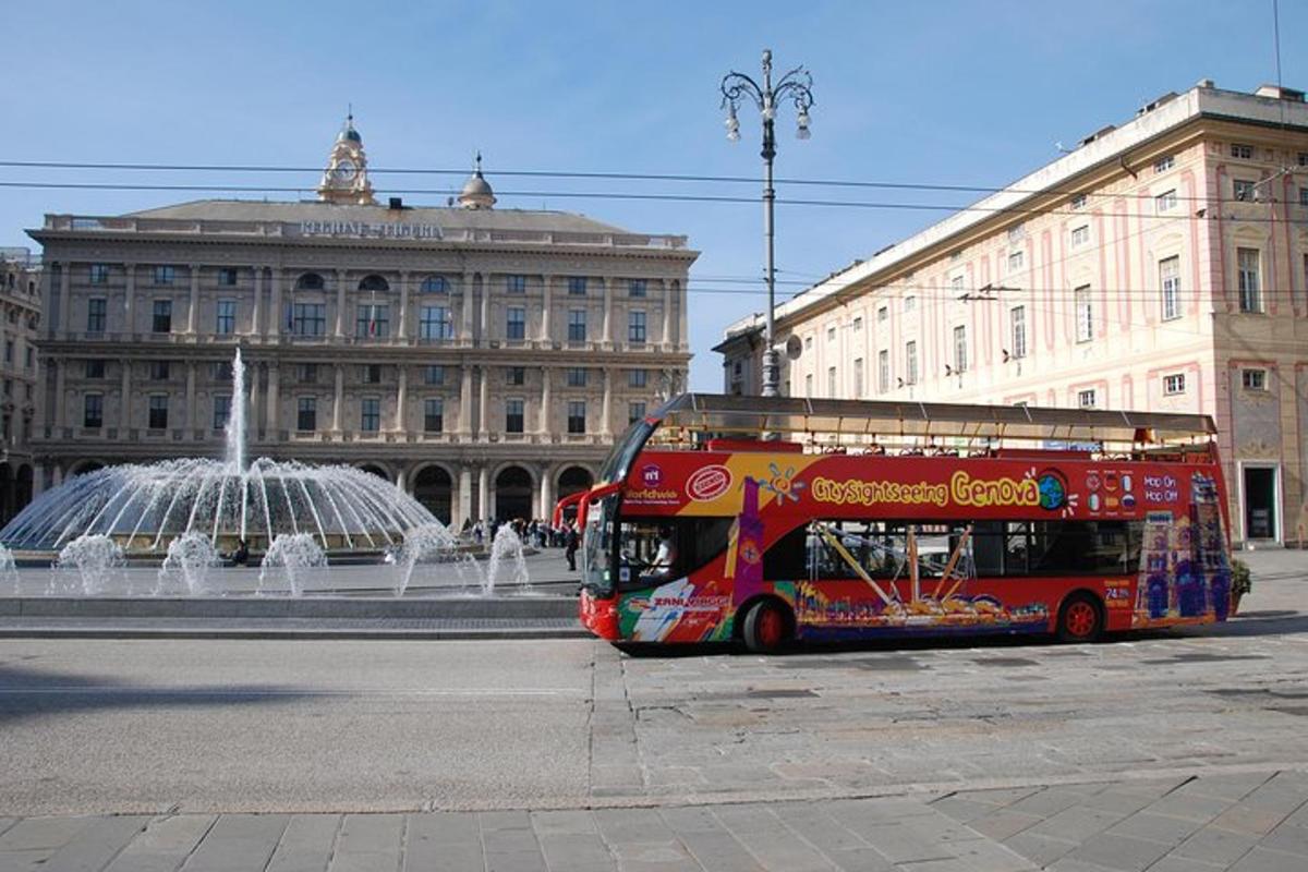 červený dvoupatrový autobus zaparkovaný před fontánou