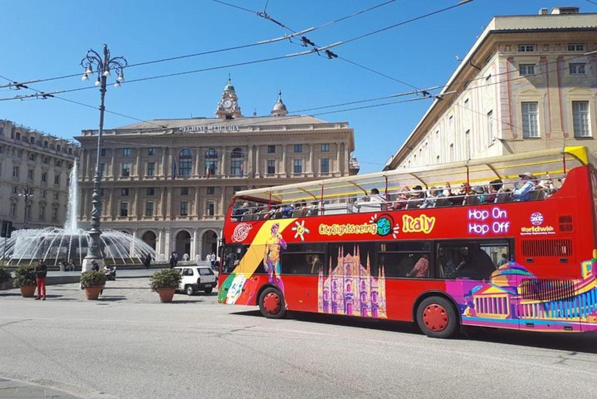 červený dvoupatrový autobus jedoucí po ulici