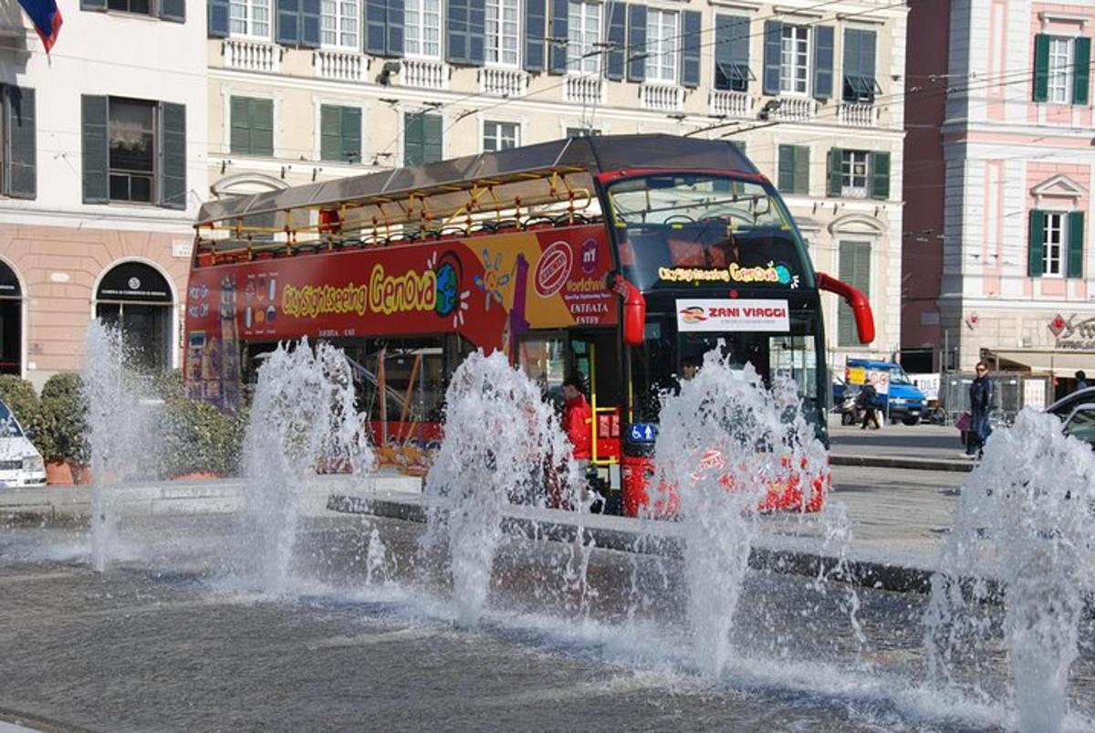 a double decker bus driving past a water fountain