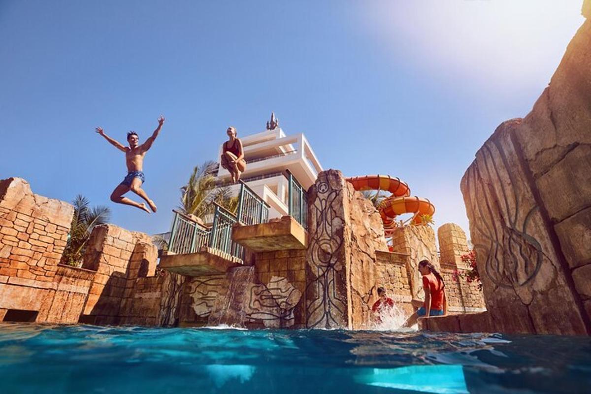 a group of people jumping in the water at a water park