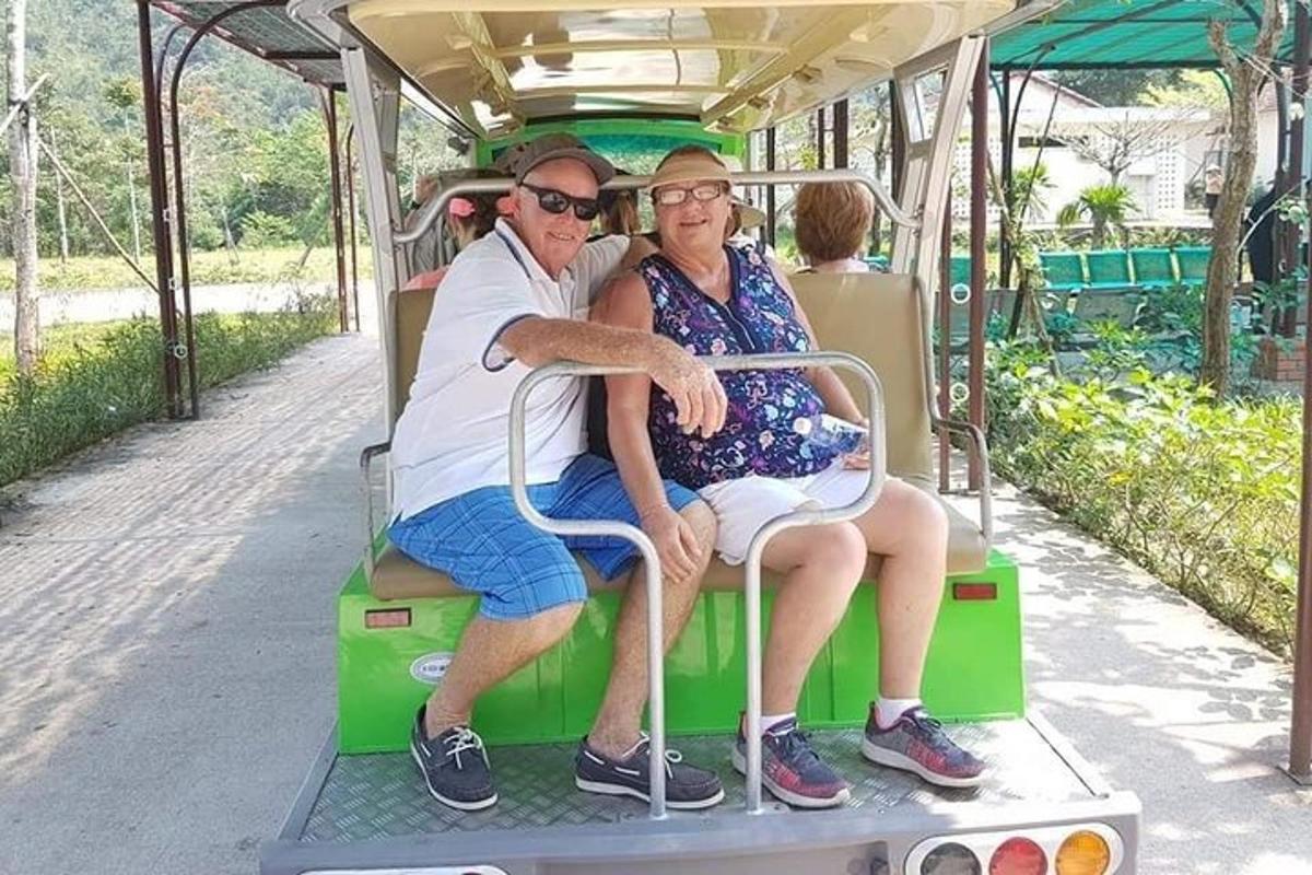 Un hombre y una mujer sentados en un carrito de golf