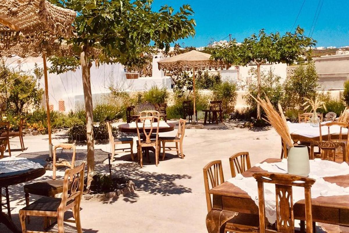 Un patio al aire libre con mesas, sillas y árboles.
