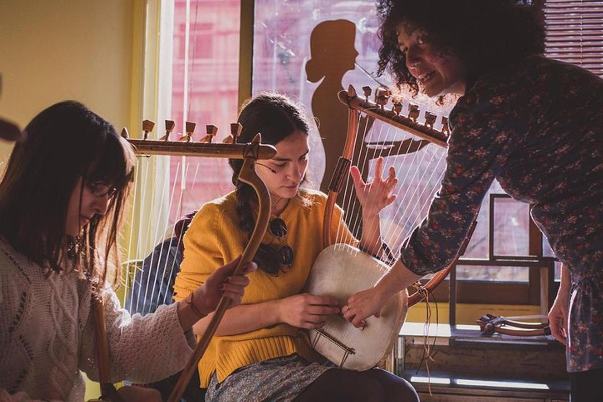 divas sievietes spēlē instrumentu ar sievieti, kas spēlē ģitāru