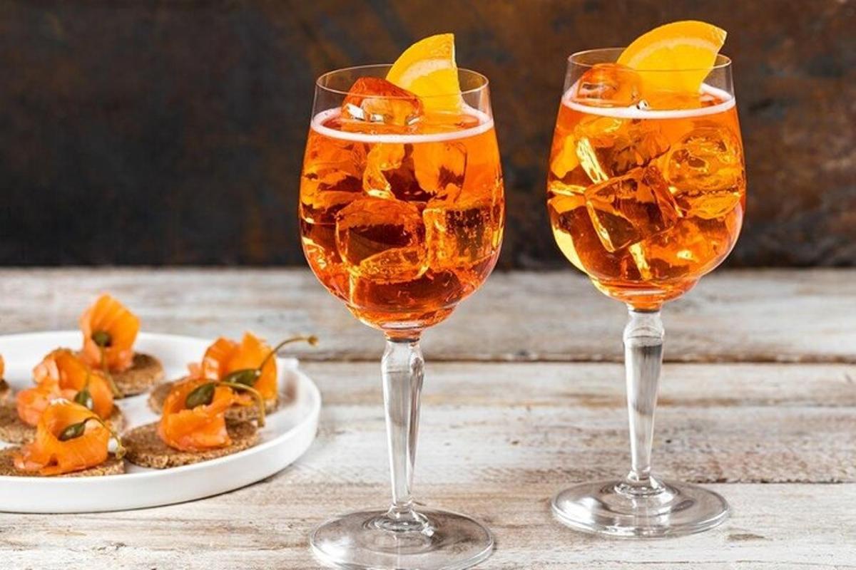 Dos copas de vino sobre una mesa con un plato de comida.