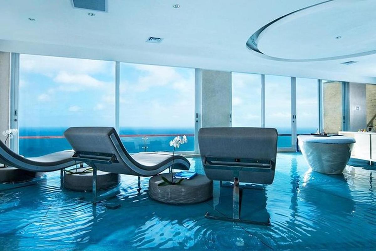 a room with two chairs and a bathtub in a building