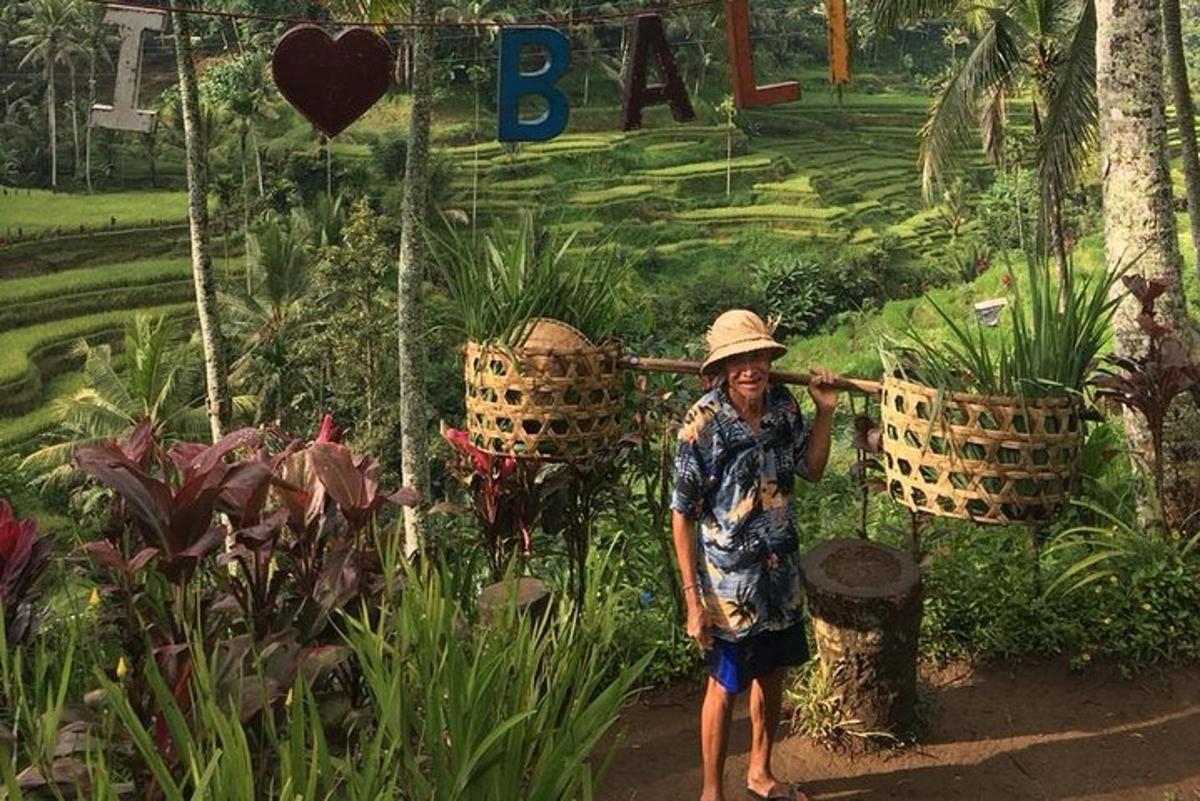 Una mujer con sombrero parada frente a un jardín.