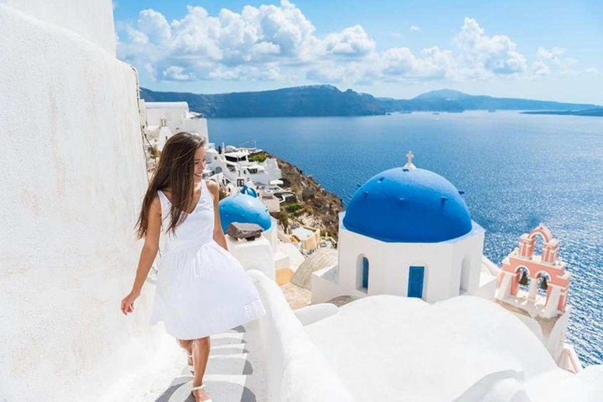 una donna in abito bianco che cammina lungo un edificio bianco