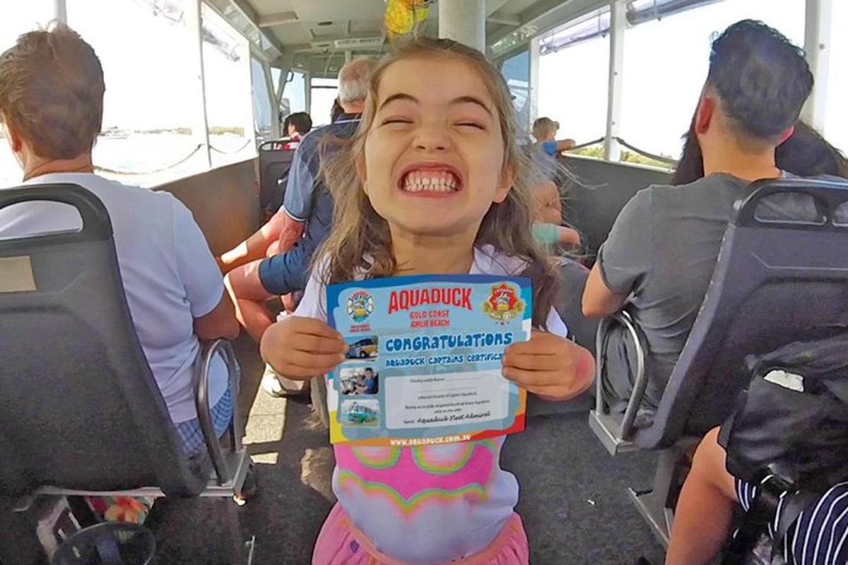 a little girl holding up a sign on a bus