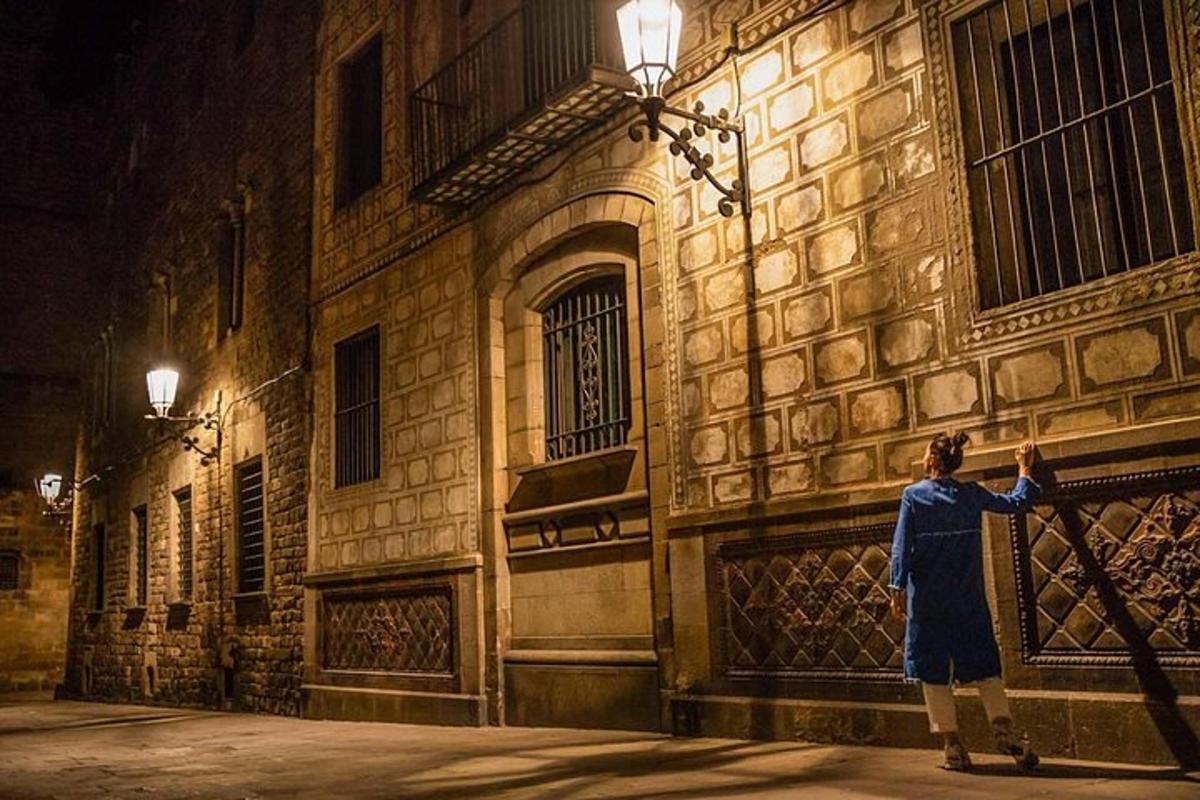 una persona parada afuera de un edificio por la noche