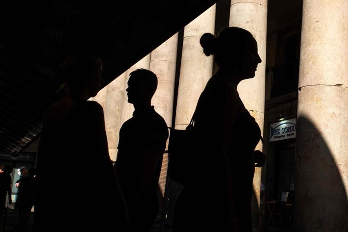 Tres siluetas de personas paradas frente a un edificio