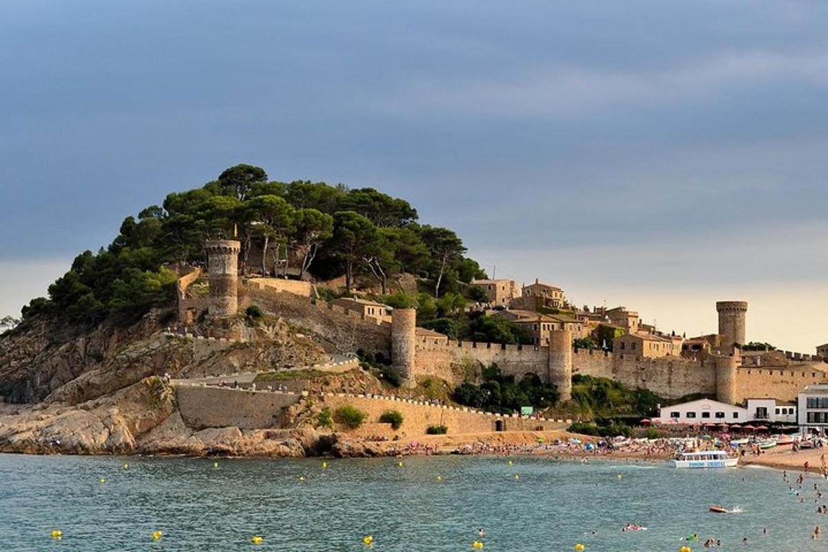un castello in cima a una collina vicino all'acqua