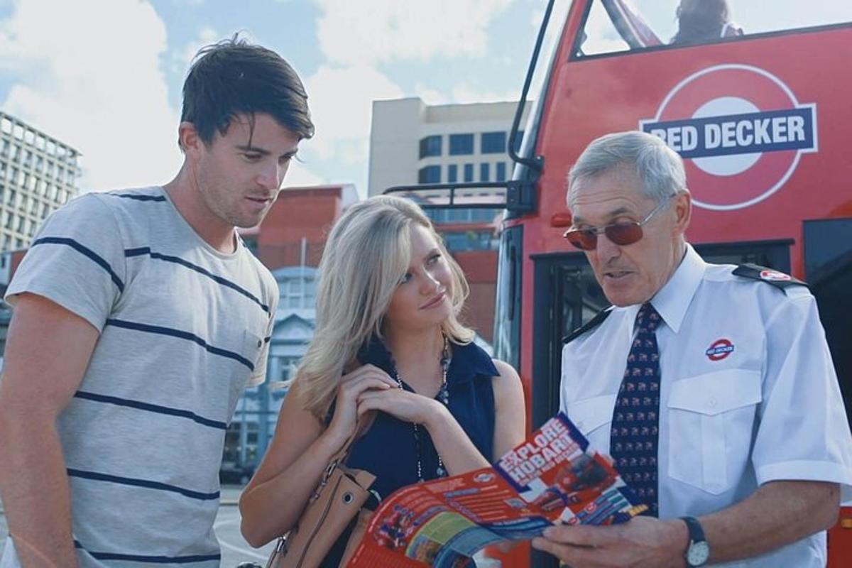 two men and a woman standing next to a bus