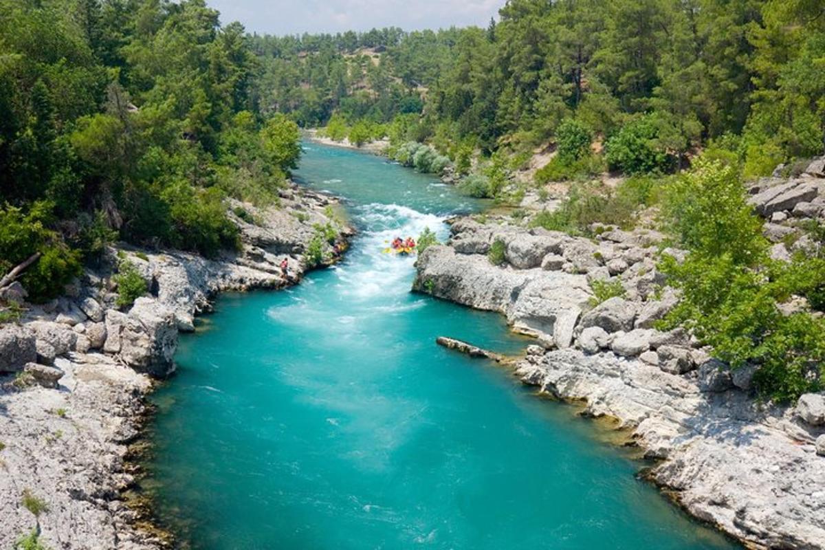 sungai dengan sekumpulan orang berakit di atasnya