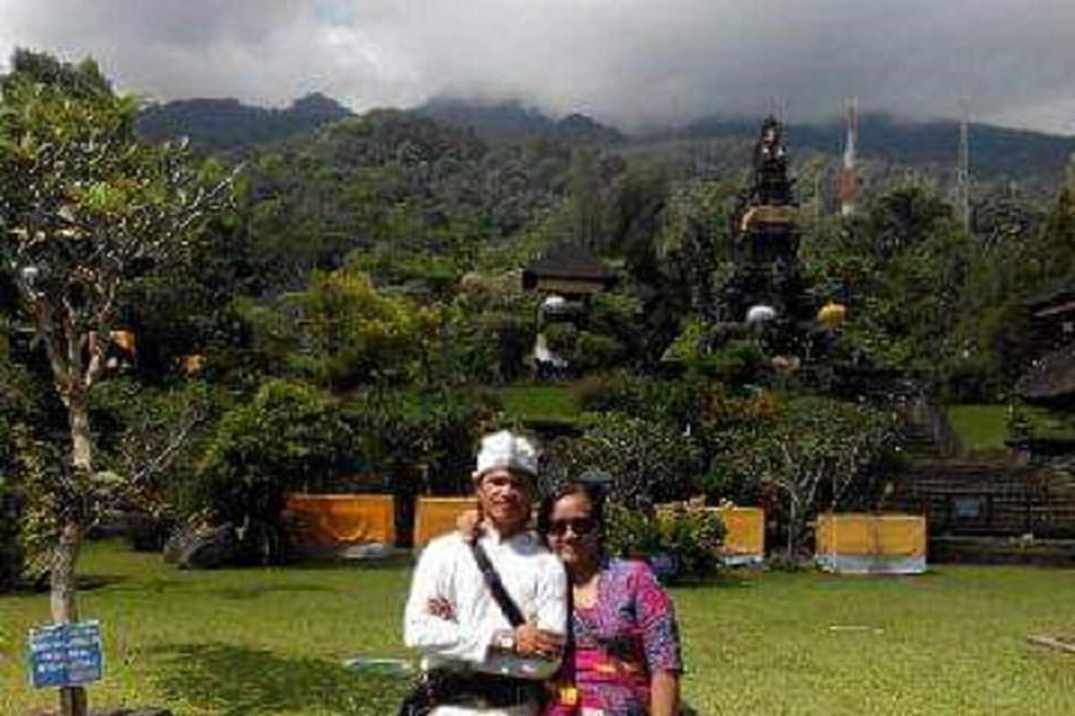 seorang lelaki dan wanita berdiri di hadapan kuil