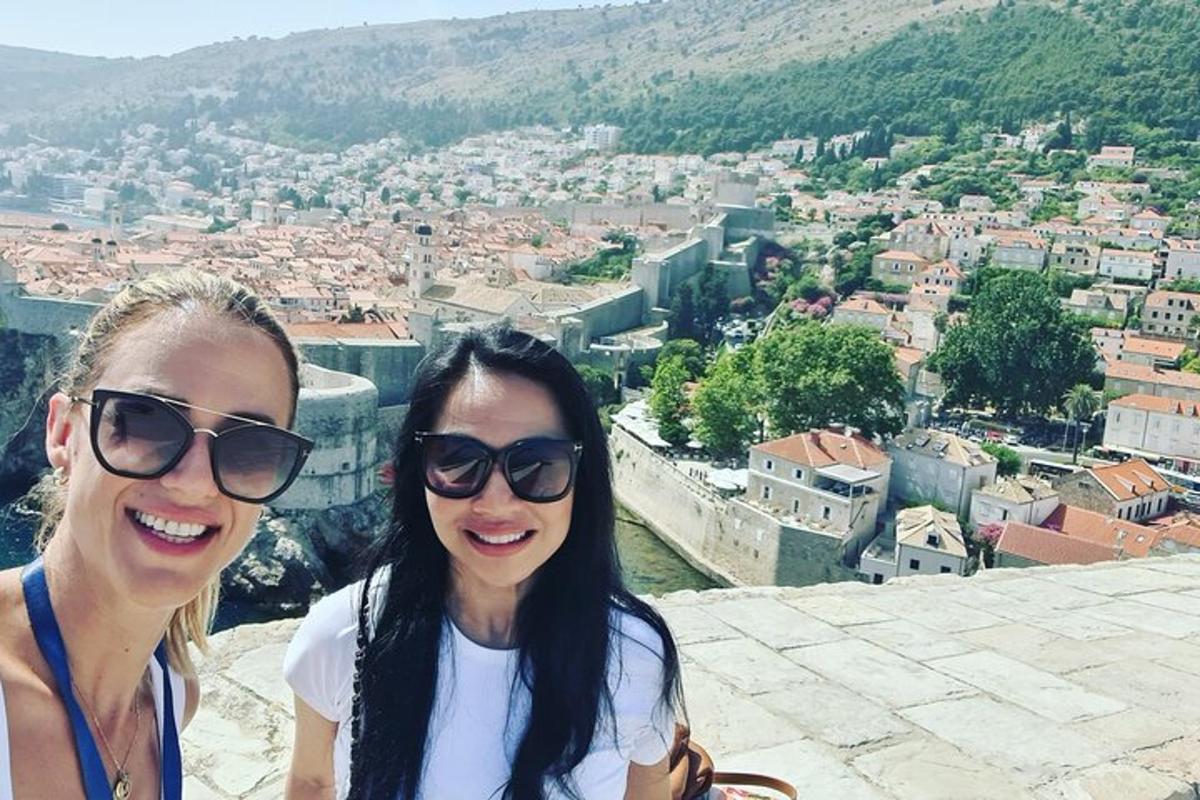dve ženski s sončnimi očali, ki stojita na vrhu mesta