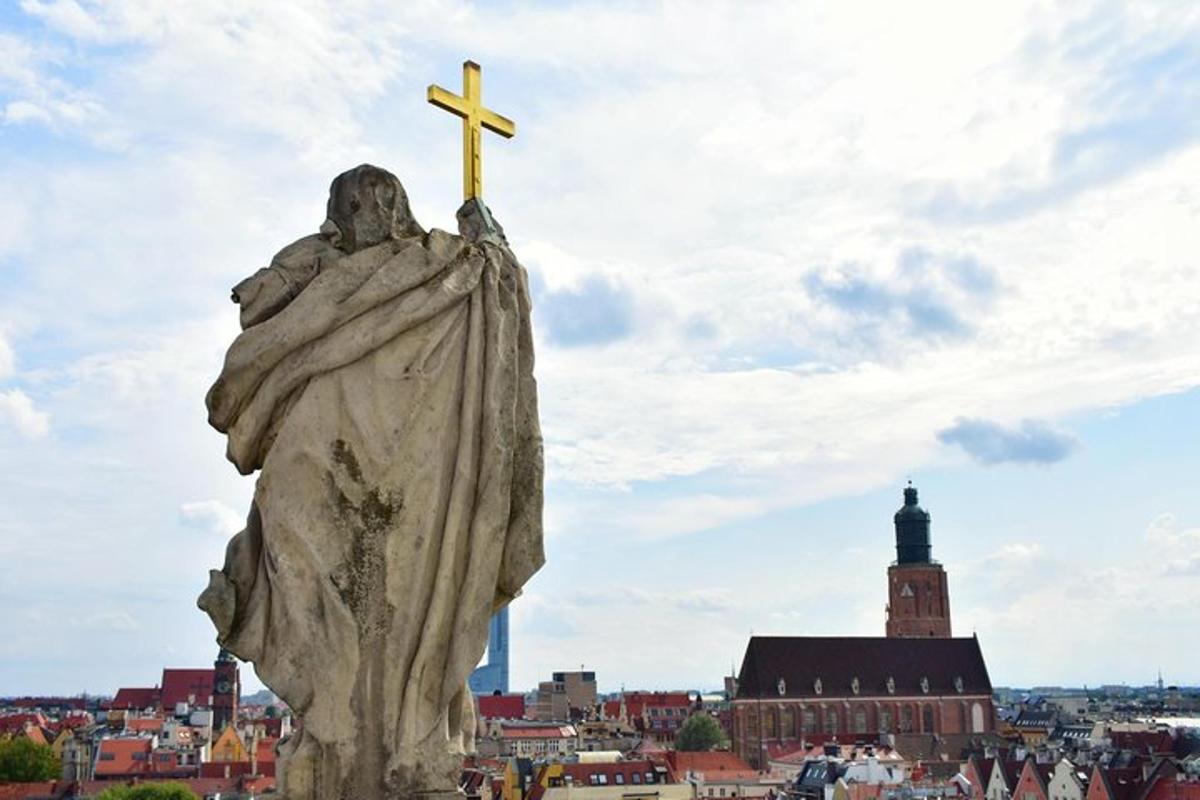 una statua con una croce in cima a una città