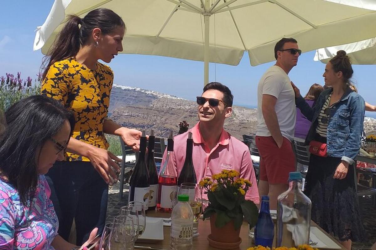 skupina ljudi, ki stojijo okoli mize s steklenicami vina