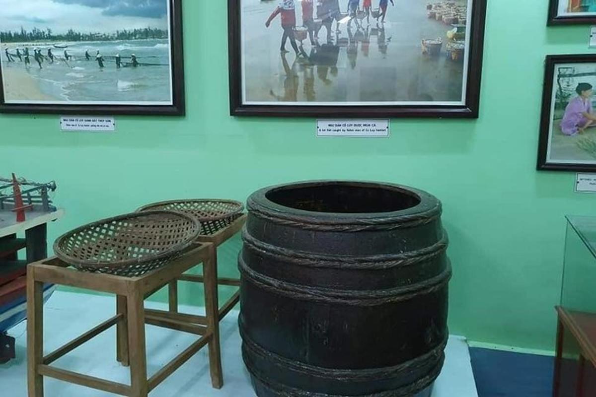 un museo con una botte, una sedia e dei quadri
