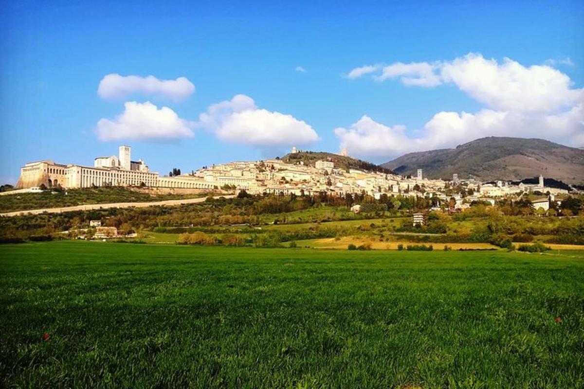 ένα καταπράσινο χωράφι με μια πόλη στην κορυφή ενός λόφου